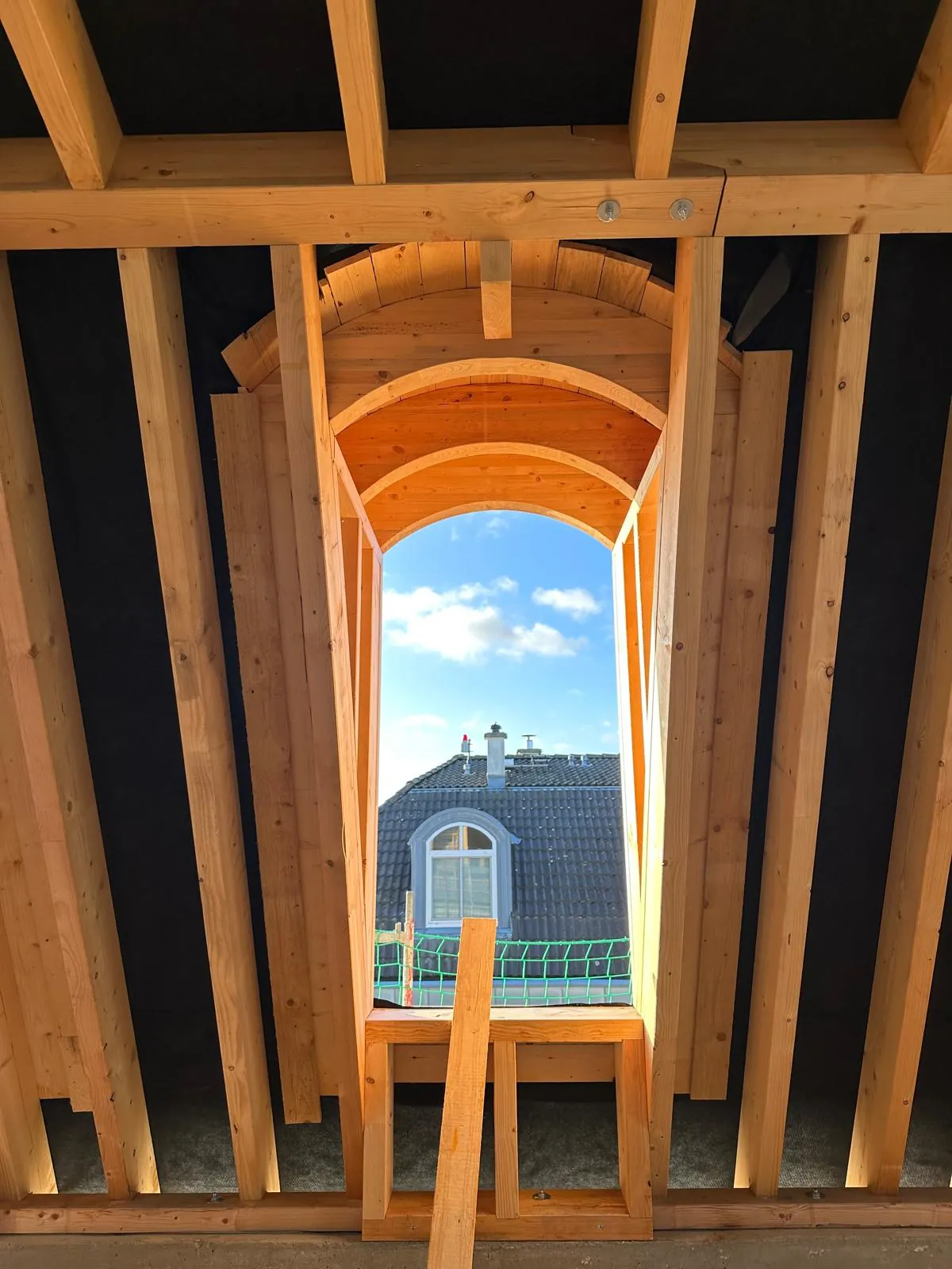 Timber frame of an arched dormer from inside