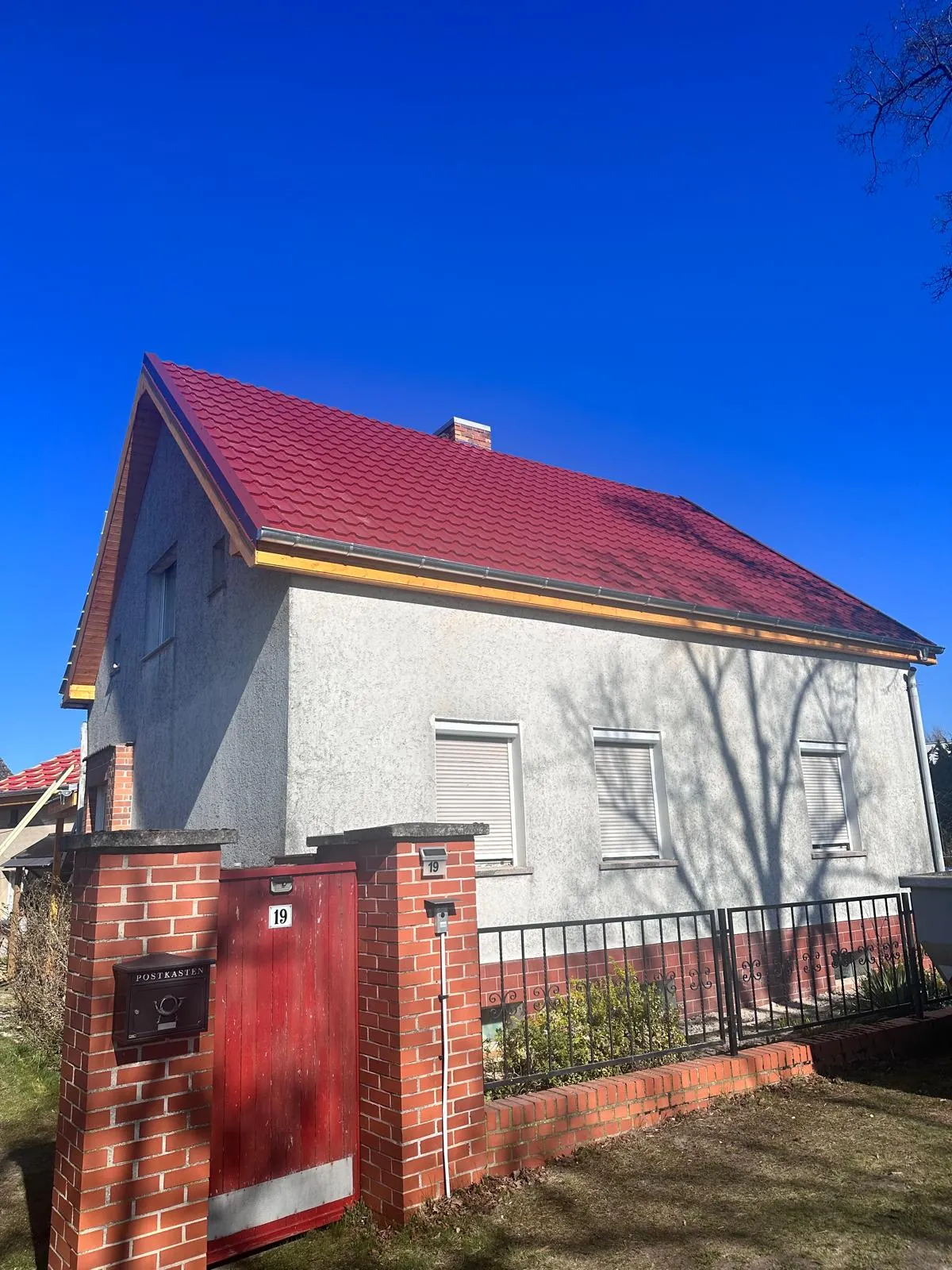 Red tile-effect metal roof on a family home