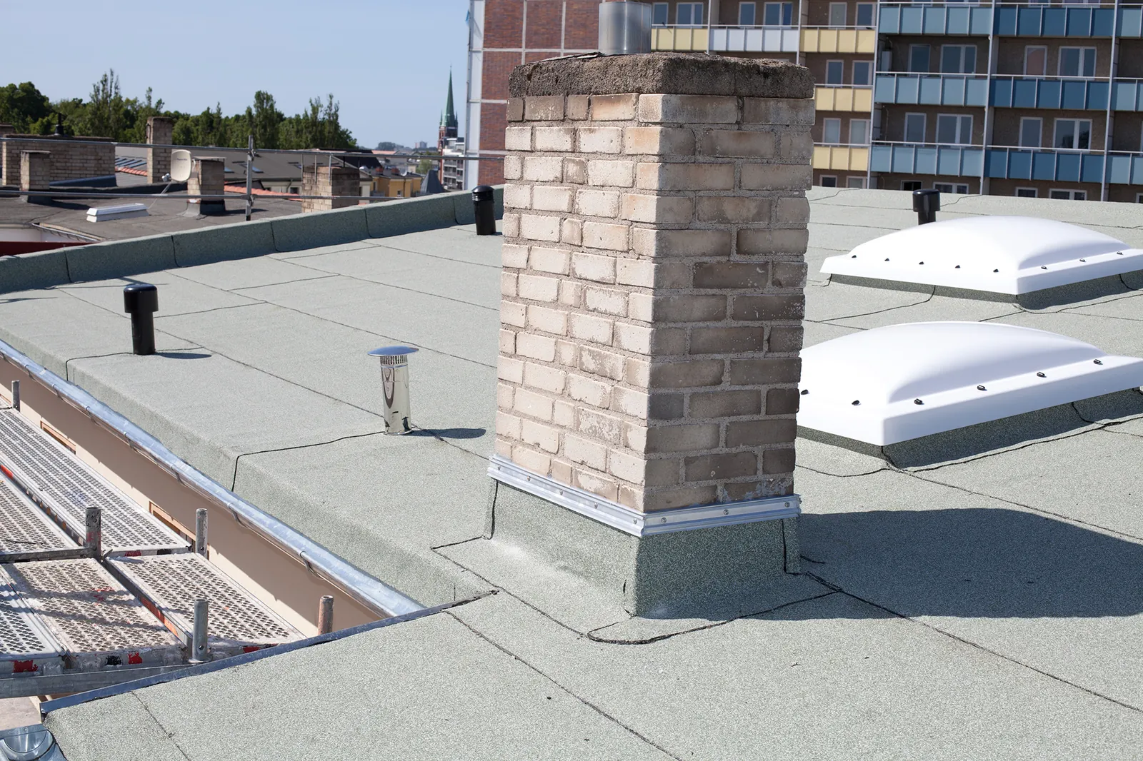 Flat roof with bitumen waterproofing, rooflights and chimney