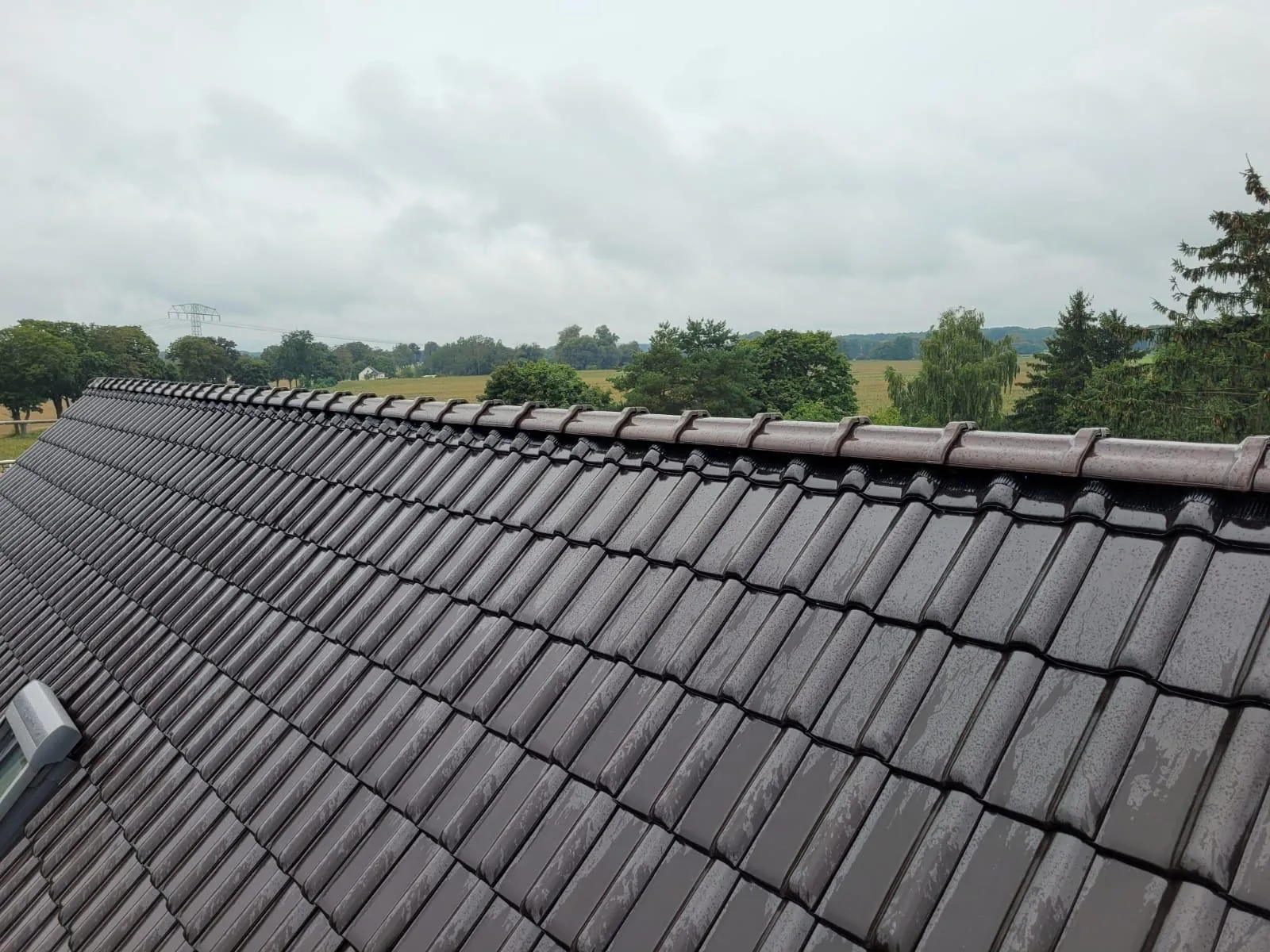 Newly tiled pitched roof with dark clay tiles