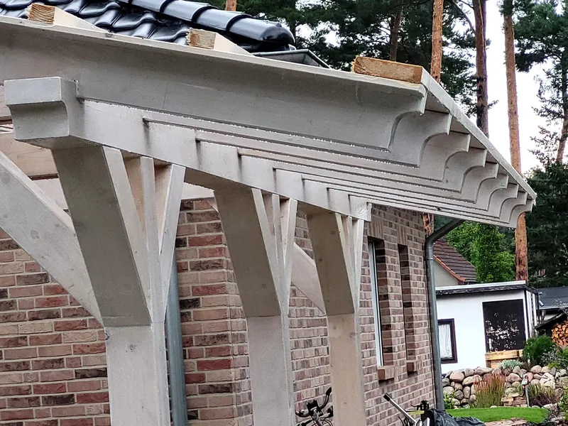 Timber canopy with decorative beams on a brick house